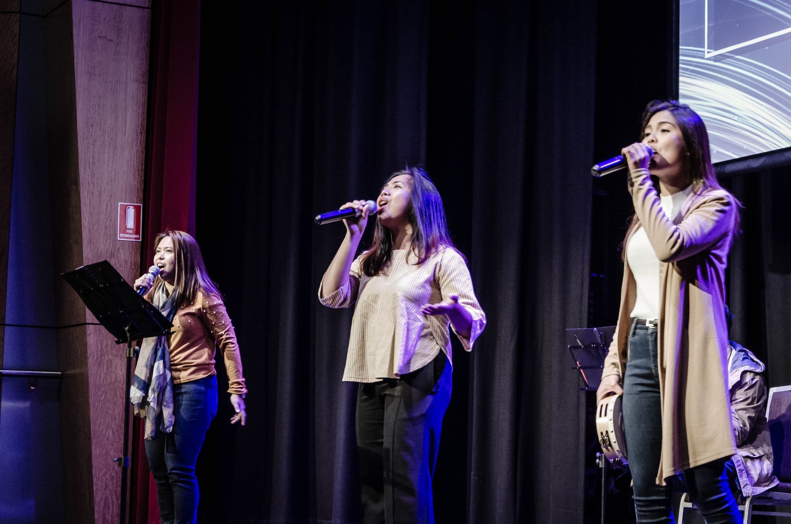 Two singers leading worship on stage at a CCF Australia service