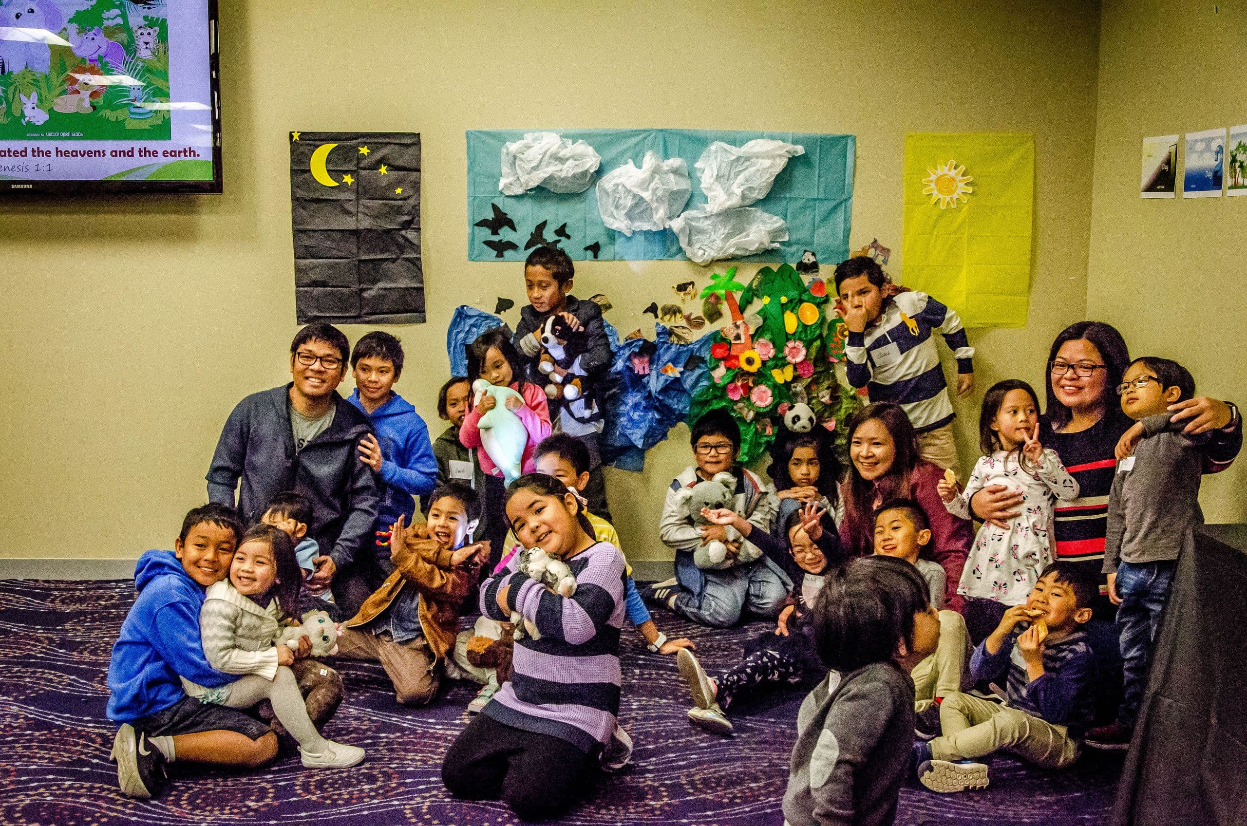 A large group of children photographed together in front of a decorated wall